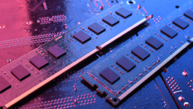 Two RAM sticks sit on a circuit board, illuminated with red and blue light.