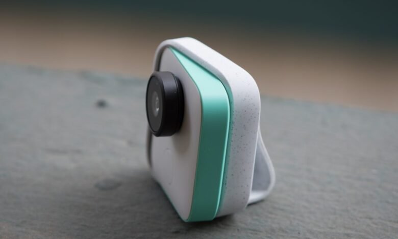 Google Clips camera with white speckled body and teal accent.