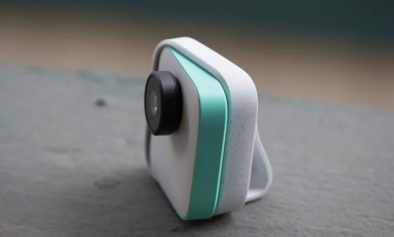Google Clips camera with white speckled body and teal accent.