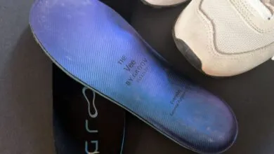 Close-up of a blue insole with a shoe on a dark surface.