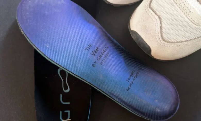 Close-up of a blue insole with a shoe on a dark surface.