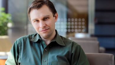 Portrait of a man with short hair wearing a green shirt.