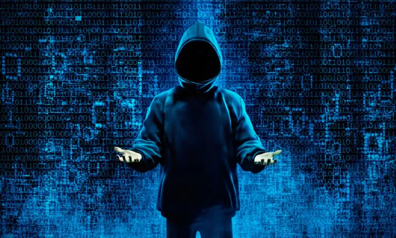 Person in hoodie with hands open against binary code background.