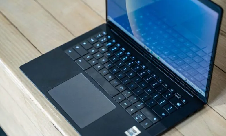 Close-up of open black HP Dragonfly Pro Chromebook on wood surface.