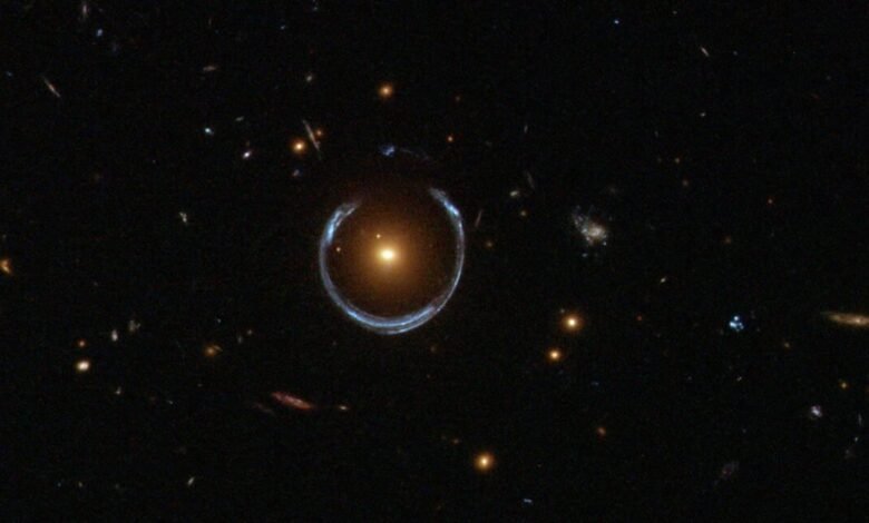 Einstein Ring LRG 3-757: A bright orange galaxy surrounded by a blue ring.