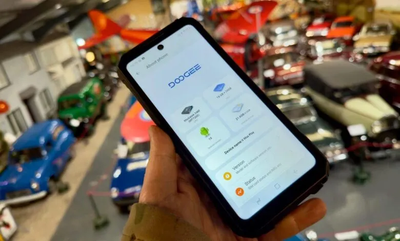 DOOGEE V Max Play smartphone displaying 'About phone' screen, held in hand.