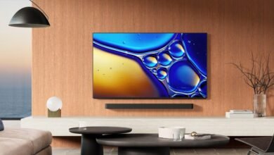 Modern living room with TV displaying abstract art and ocean view.