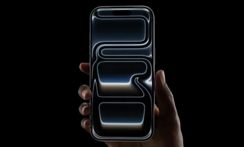 Hand holding a dark iPhone with a glowing, abstract design on the screen.