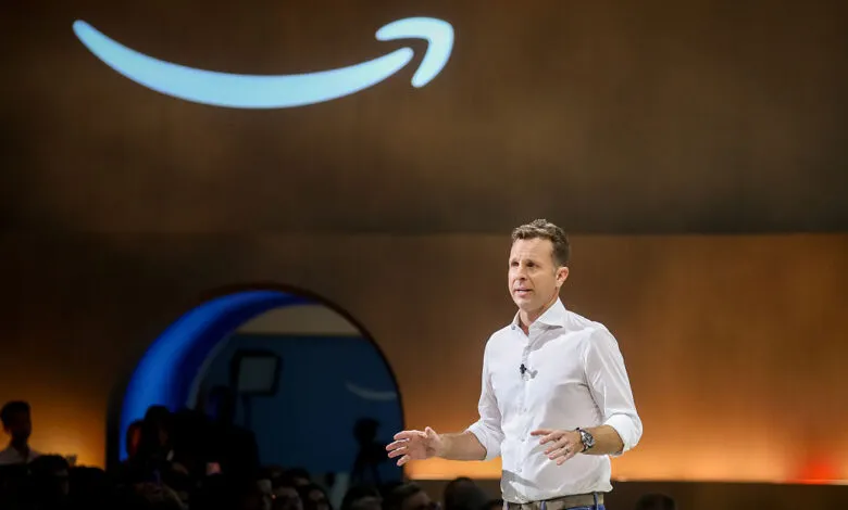 Jamie Siminoff presents at Amazon product event with logo backdrop.