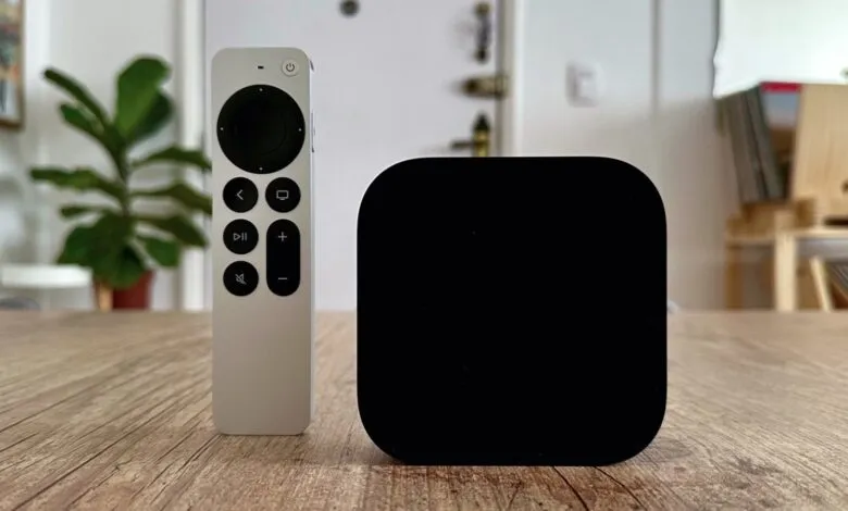 Apple TV 4K box and Siri Remote on a wooden table.