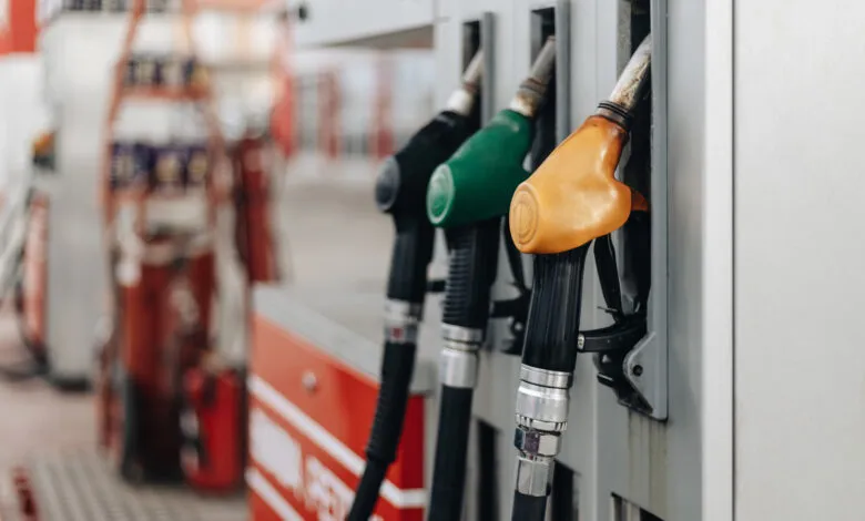 Close-up of three colorful gas pump nozzles at a filling station.