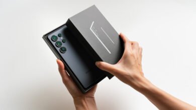 Hands opening a Samsung Galaxy S23 Ultra box, revealing the phone.