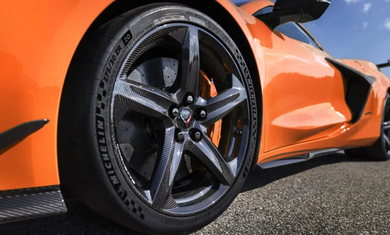 Close-up of an orange Corvette's carbon fiber wheel and Michelin tire.