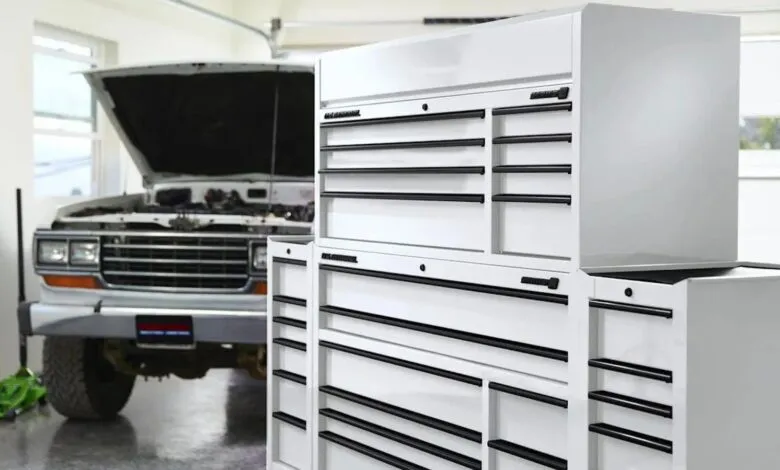 White tool chest in garage with vehicle hood open.