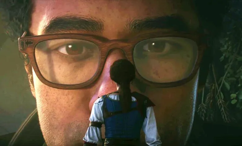 Woman stands before a giant face wearing glasses, creating a surreal perspective.