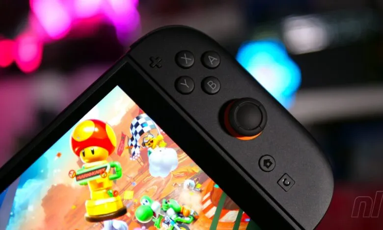Close-up of a Nintendo Switch OLED playing Mario Kart, focus on controller.