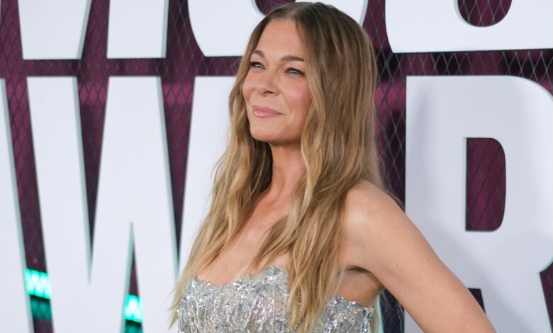 LeAnn Rimes poses in a shimmering silver dress on the red carpet.