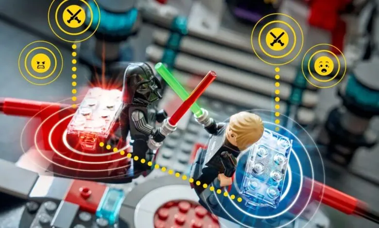 Lego Darth Vader and Luke Skywalker minifigures duel with lightsabers.