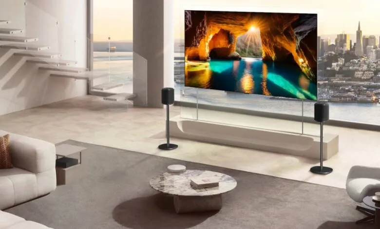 Modern living room with large OLED TV displaying a cave scene and a city view.