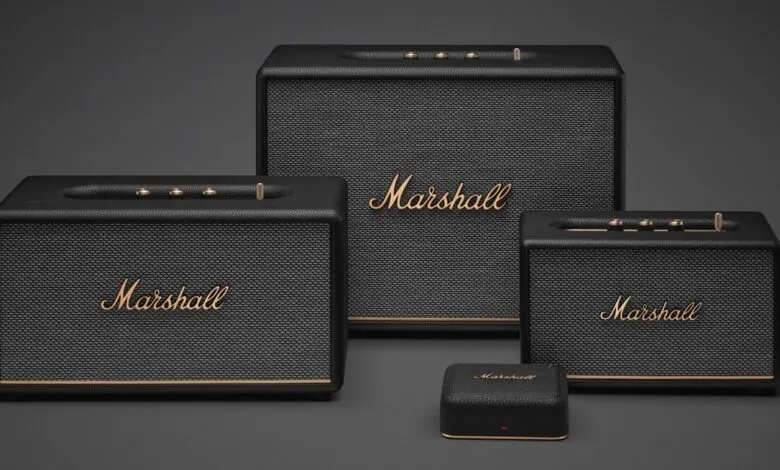 Three Marshall speakers and a small device on a gray background.