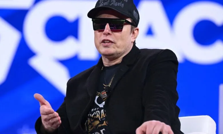Elon Musk wearing sunglasses and a 'Make America Great Again' hat.