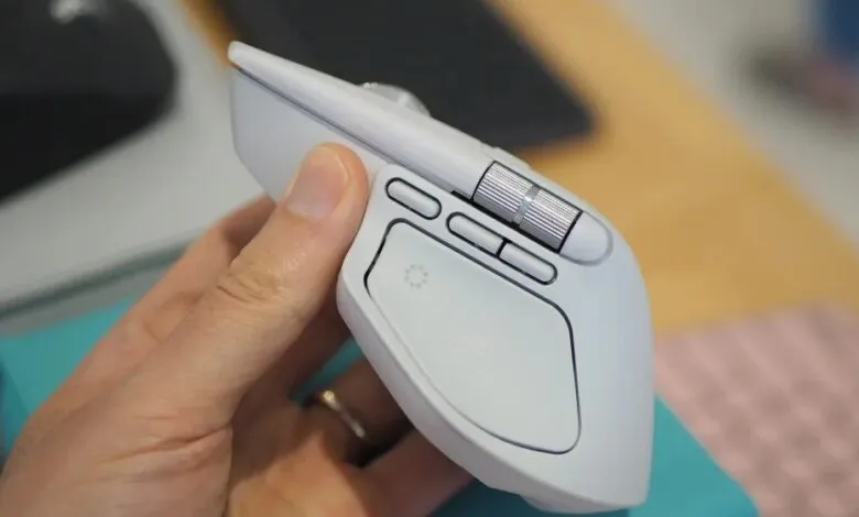 White Logitech MX Master 3S mouse held in hand, close-up.