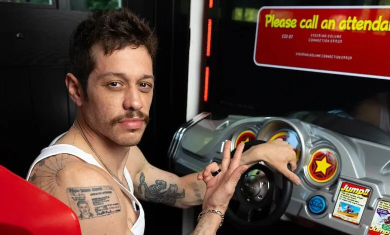 Pete Davidson sits in a racing game with error message on screen.