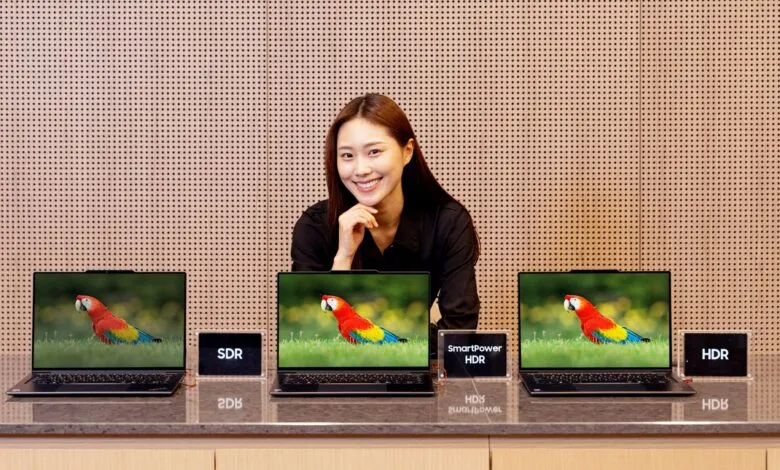 Woman presents laptops with parrot image, showing SDR vs HDR display quality.