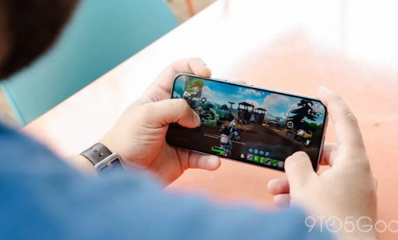 Person playing Fortnite on a smartphone in landscape mode.