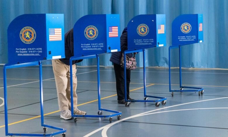 People voting in blue booths with American flags and Nassau County seals.