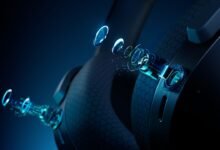 Close-up of black headphones with glowing blue tech details.
