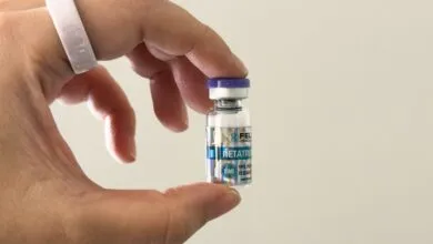 Hand holds vial labeled Retatrutide, a research chemical.