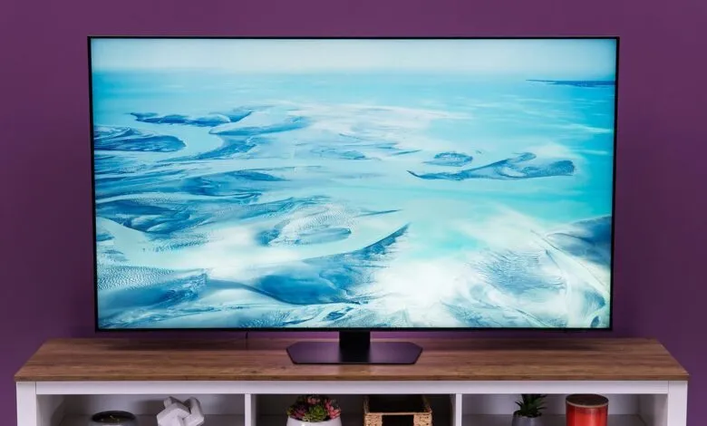 Large flat screen TV displaying a serene coastal landscape scene.