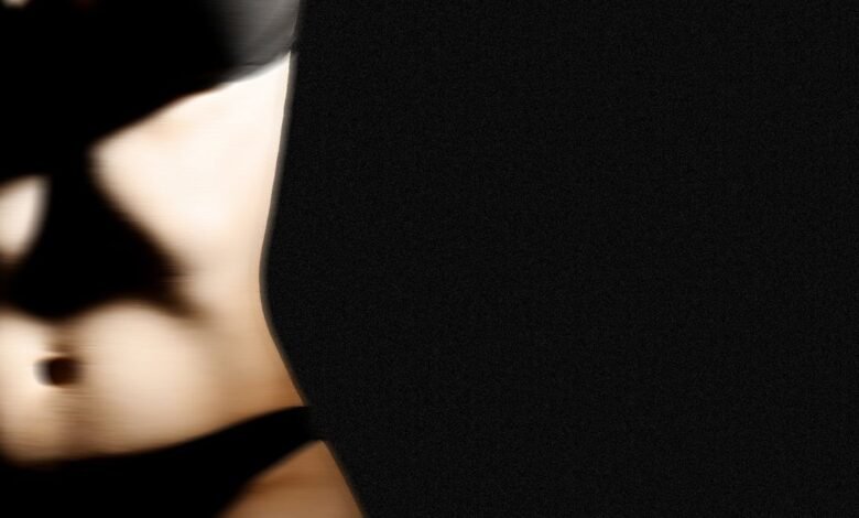 Abstract blurred image of a torso against a dark background.