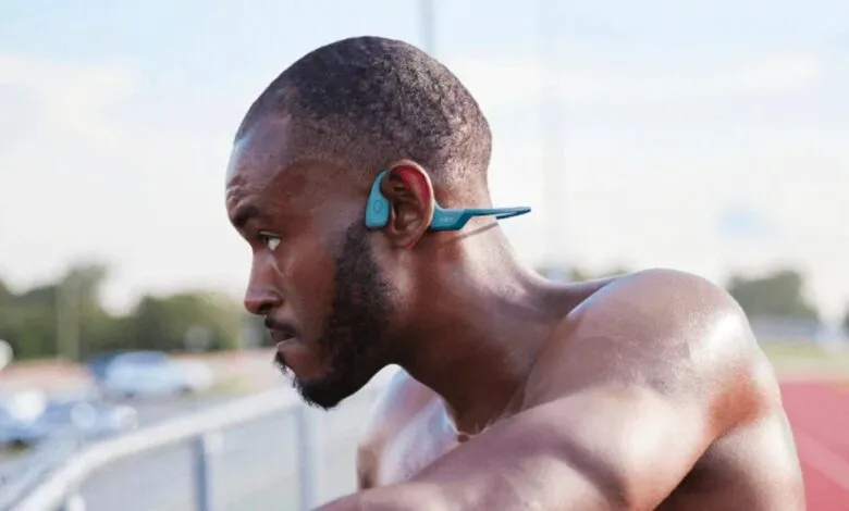 Athlete wearing blue Shokz OpenRun Pro bone conduction headphones.