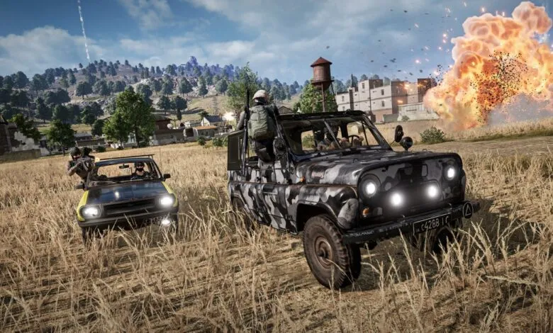 Two off-road vehicles with armed occupants in a grassy field near an explosion.