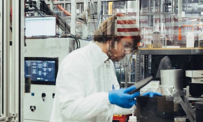 Scientist in lab coat and gloves working in a modern laboratory setting.