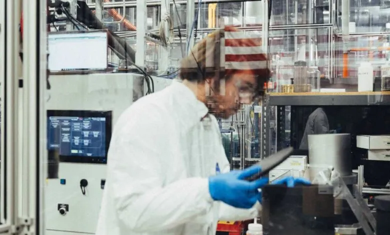 Scientist in lab coat and gloves working in a modern laboratory setting.