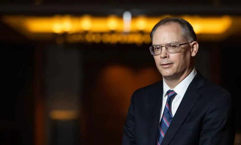 Portrait of a man wearing glasses and a suit.
