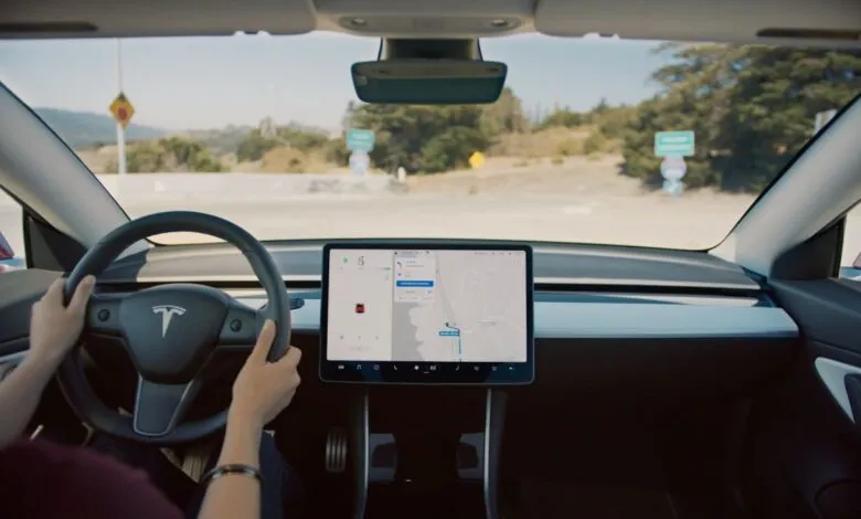 Interior view of Tesla car with hands on steering wheel and navigation screen.