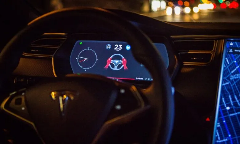 Tesla dashboard view showing autopilot engaged at 23 mph at night.