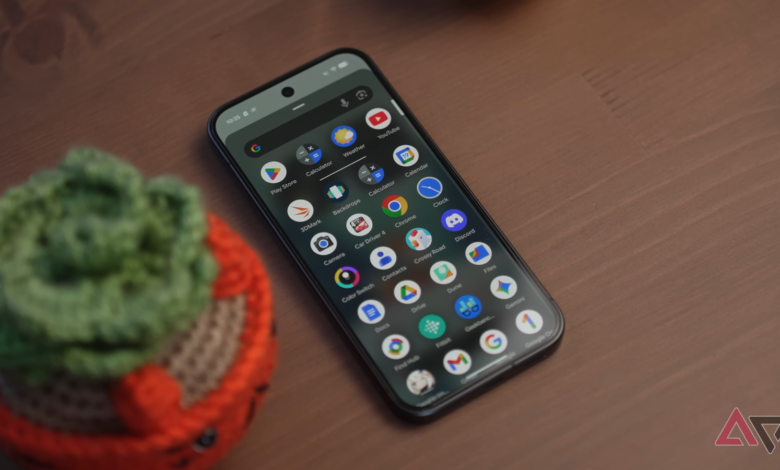 Smartphone displaying app icons on a wooden surface with a small plant.