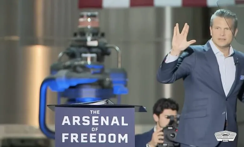 Man in suit gestures at 'Arsenal of Freedom' event.