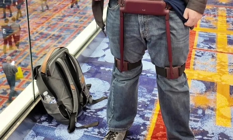 Person wearing wearable tech on legs, backpack nearby.