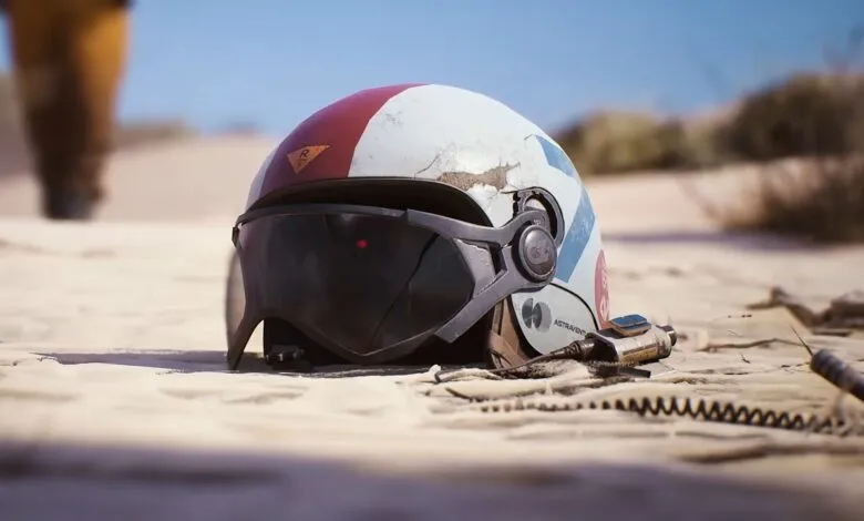 Worn astronaut helmet on sandy surface with attached equipment.