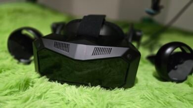 Black VR headset and controllers on a bright green, fluffy surface.