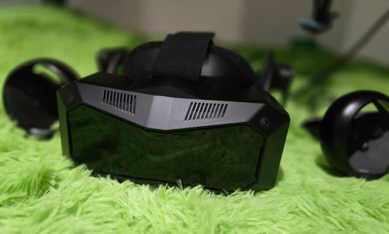 Black VR headset and controllers on a bright green, fluffy surface.