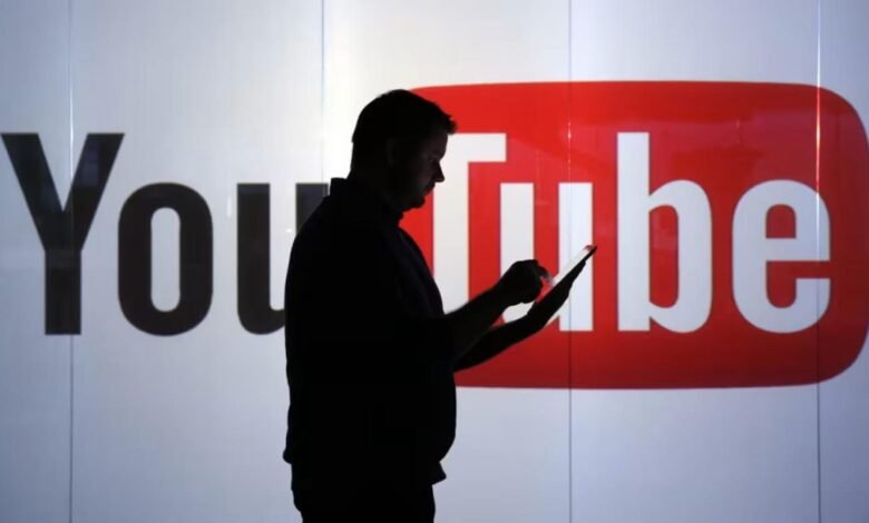 Silhouette of person using tablet in front of YouTube logo.