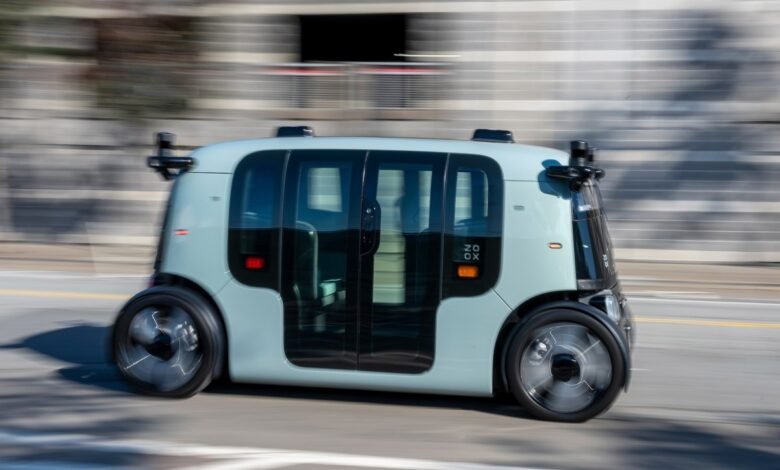 Zoox autonomous vehicle driving on a city street, motion blur.