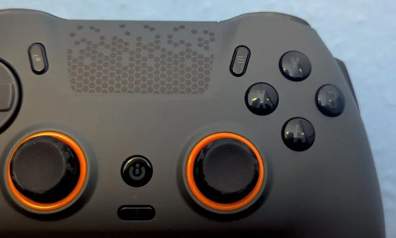 Close-up of a black gaming controller with orange accents.